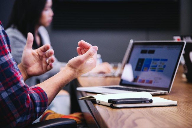 A sales coach leading a group training session with diverse participants actively engaged in a discussion about sales strategies.